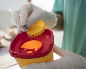 Nurse throwing away used syringe