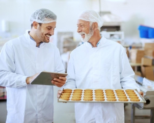 Two bakers in kitchen laughing