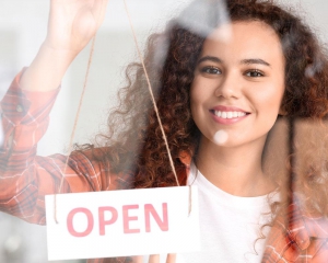 Employee flipping sign in window to "open"