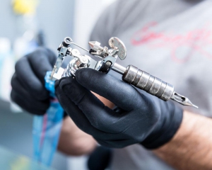 Tattoo artist holding tattoo gun