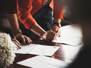 Photo of office worker signing papers